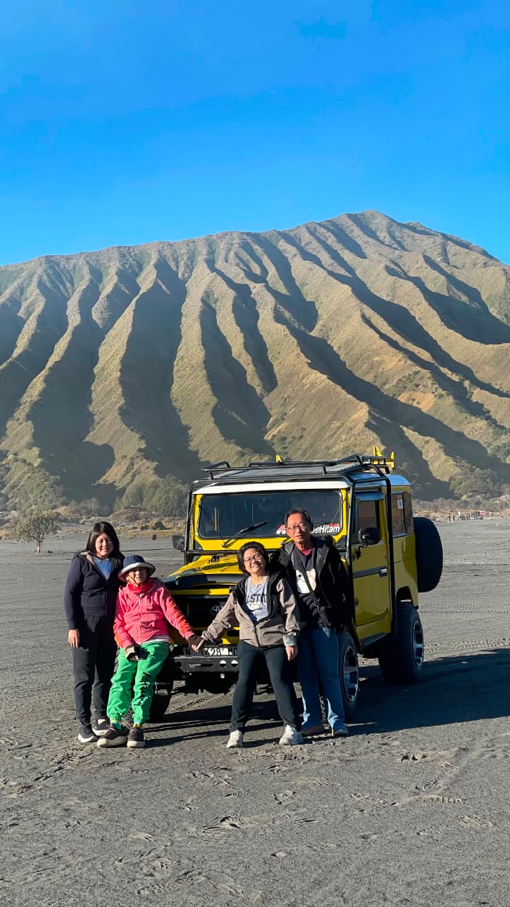 Ms rosie from taiwan and family taking a photo with a bromo jeep at mount bromo